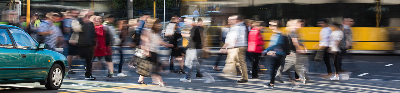 A time lapse image of people crossing the road at a busy intersections