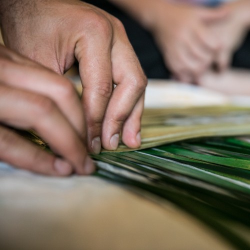 Materials Pair of male hands folding flax leaves.