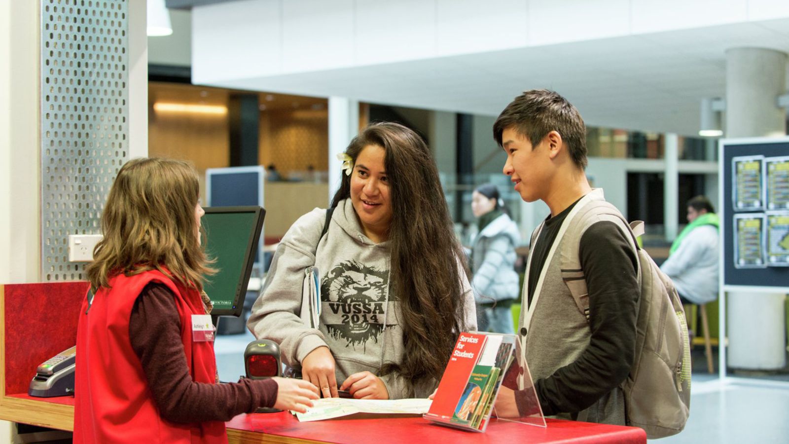 Students standing at an information desk