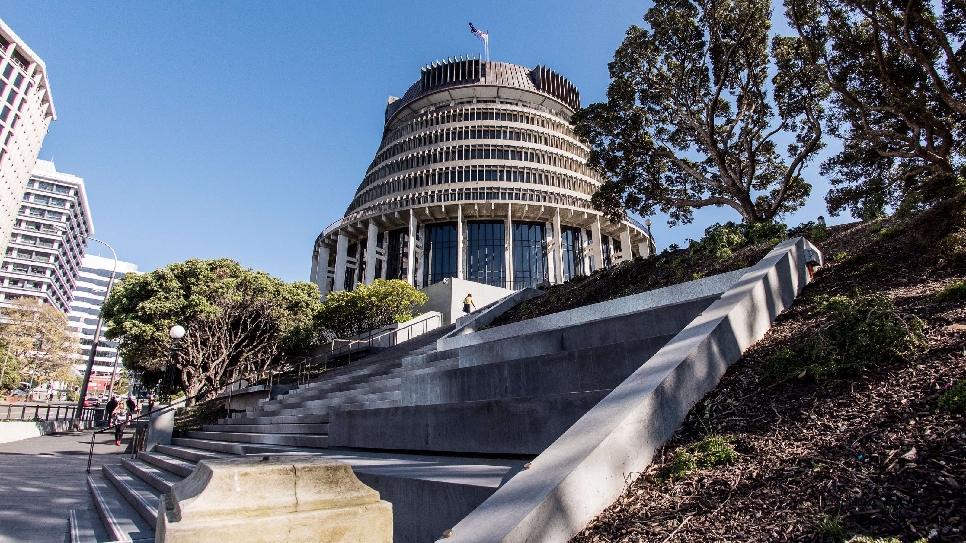 Concrete steps in the foreground leading up to the Wellington Beehive and trees in the background. 
