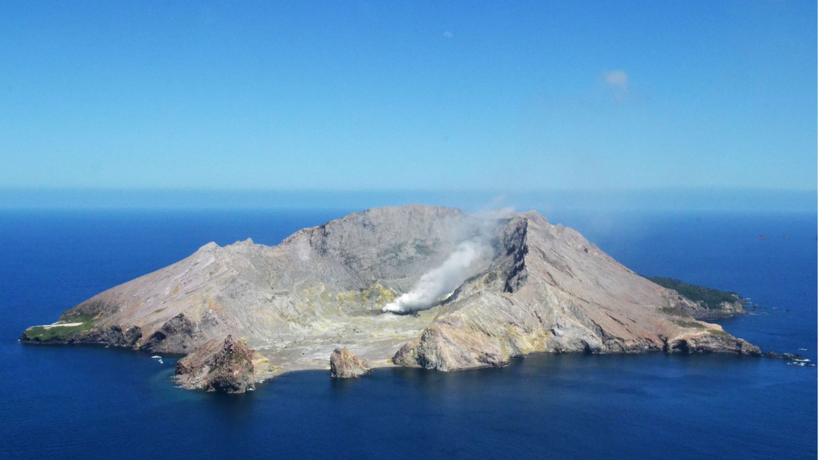 Whaakari / White Island, a volcanic rupture in earth's crust, with a plume of toxic smoke escaping from its magmatic, subterranean heart.