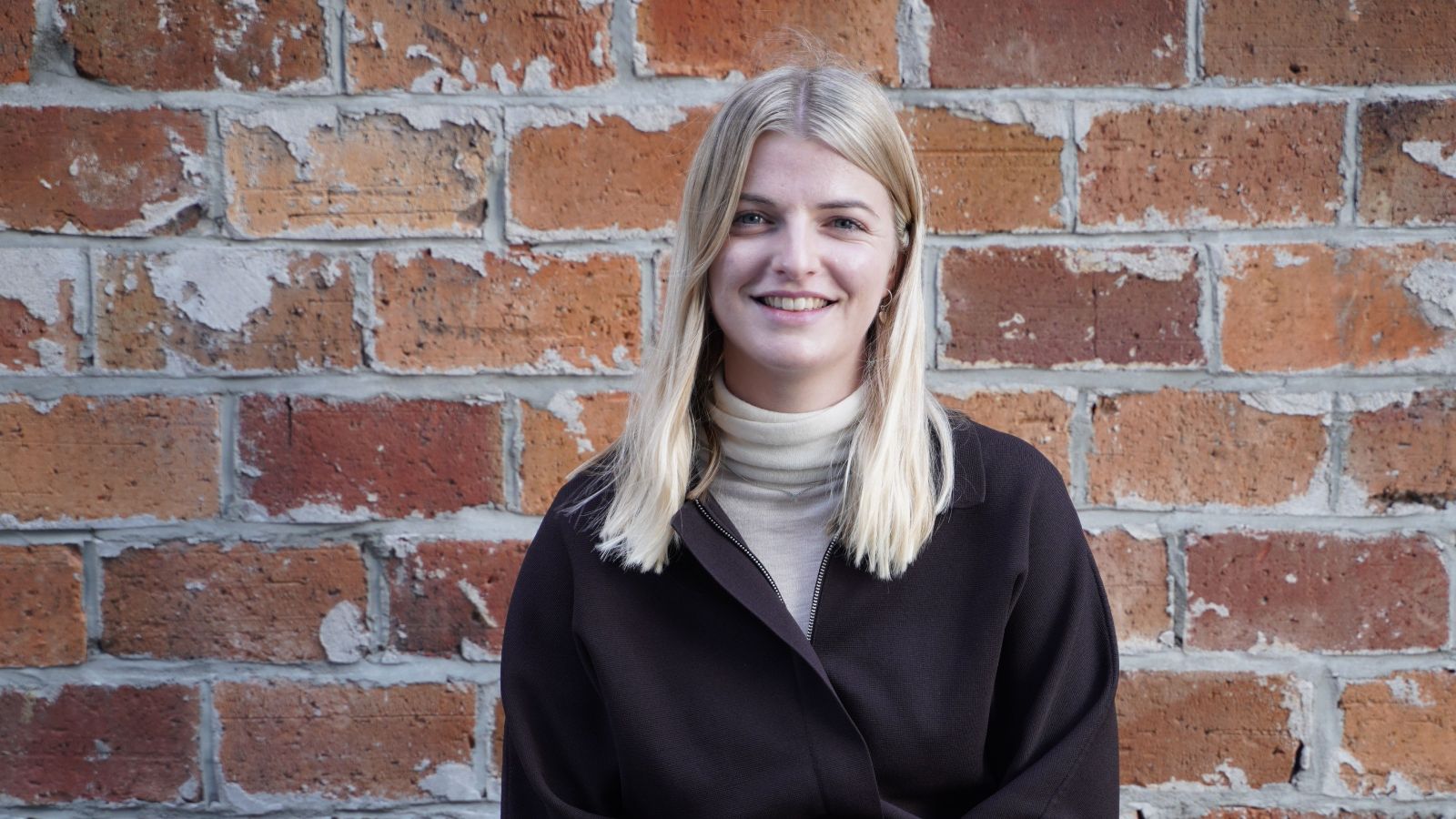 Tessa Lynch in front of brick wall