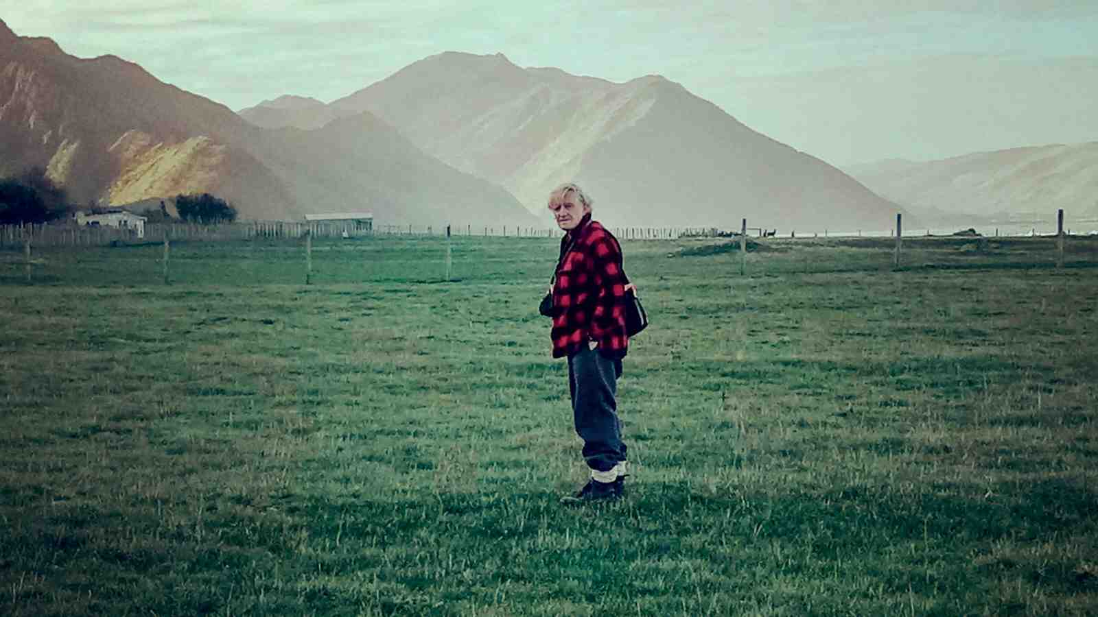 Dr Bruce McFadgen standing in a grassy field