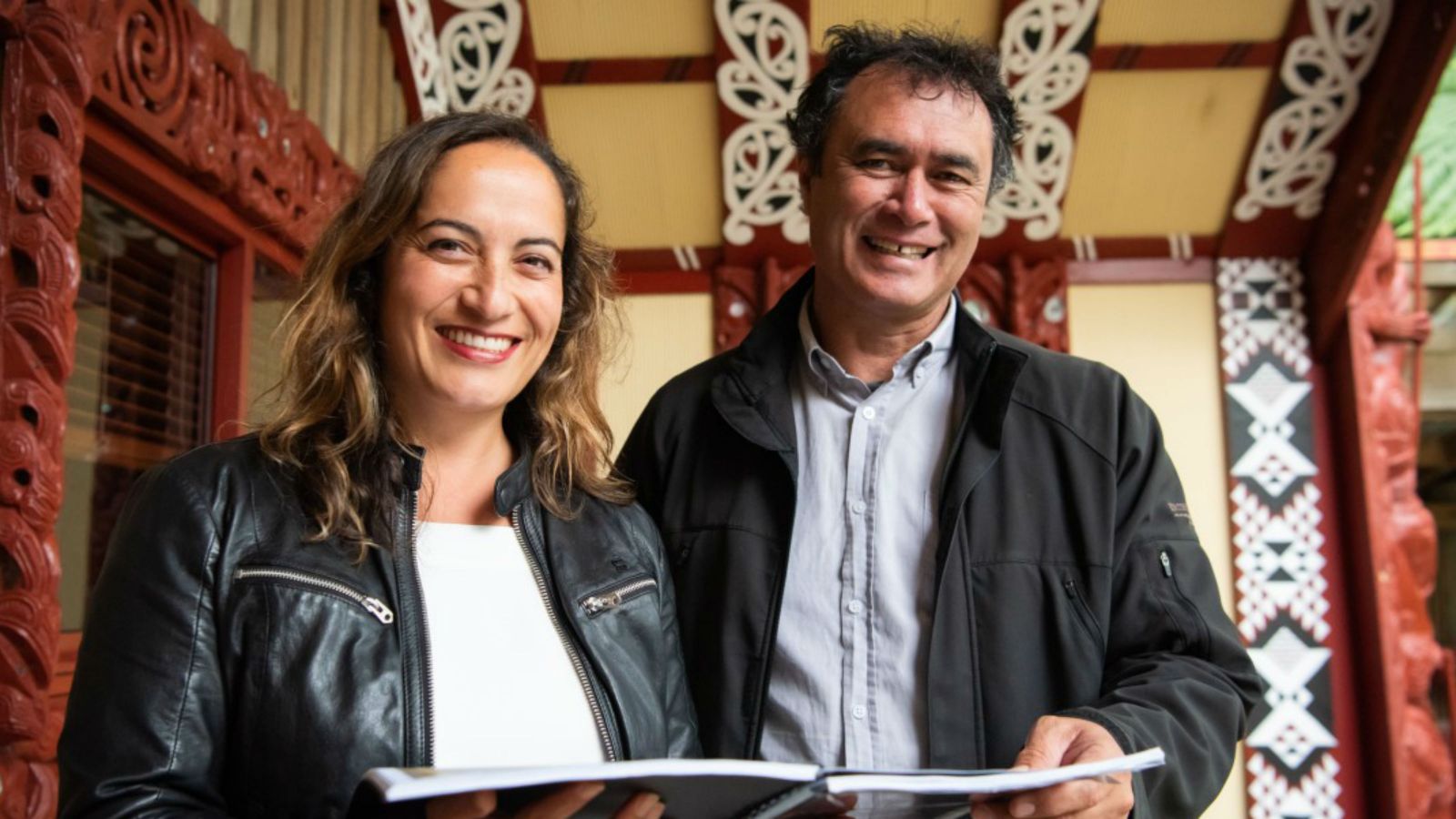 Arini Loader and Mike Ross on Victoria University of Wellington marae with a copy of the waiata at the heart of their research project.