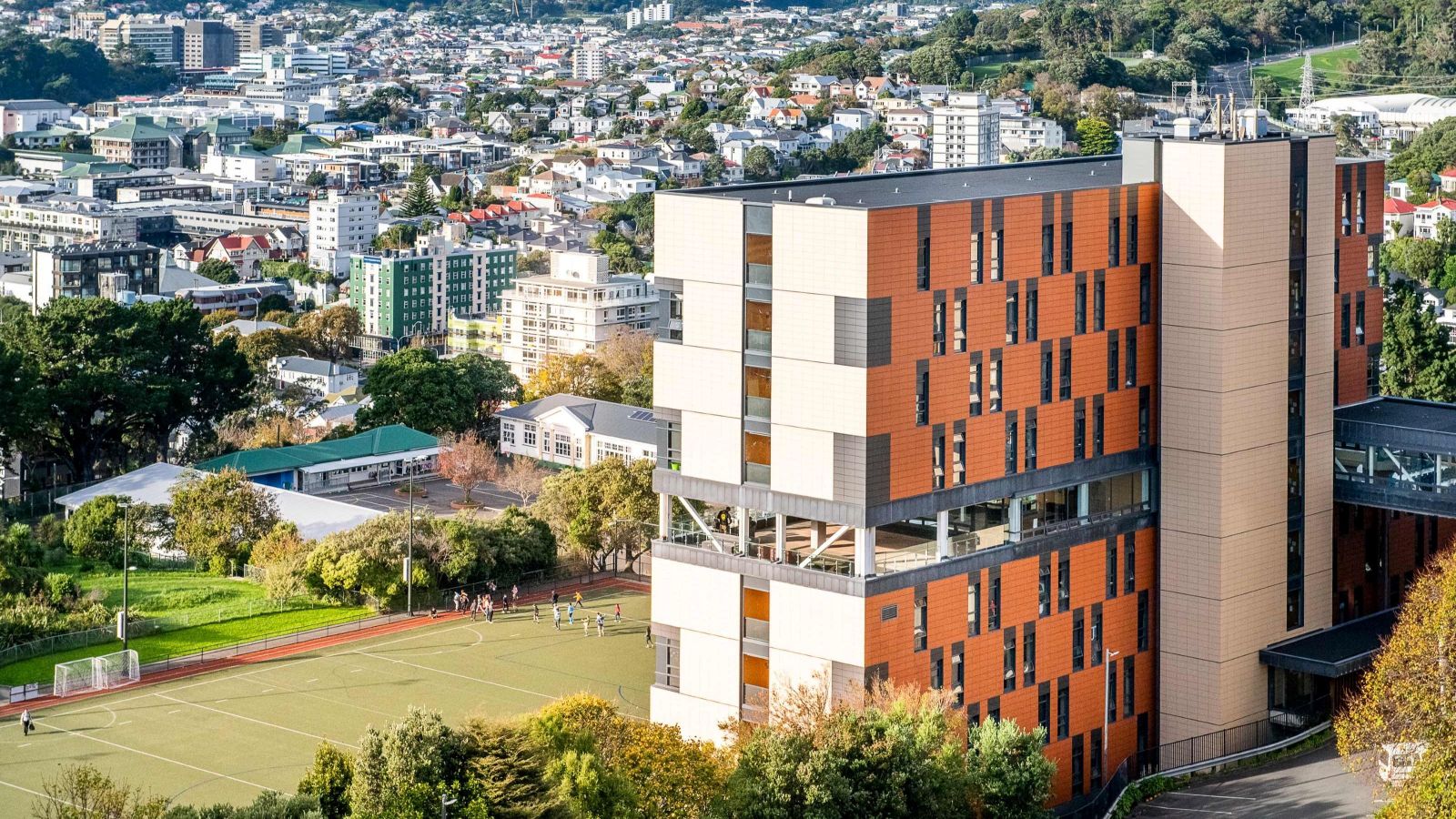 The exterior of Te Puni Village, overlooking a sports field, and Wellington city.