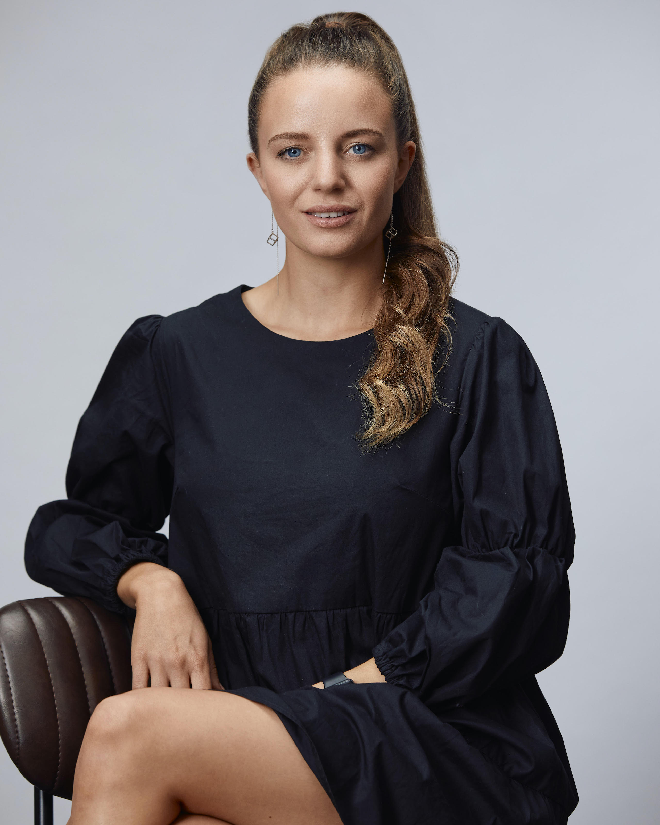 EMily Newmarch sitting on a chair looking straight to camera.