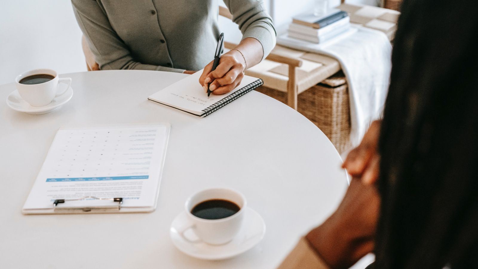 Two people having a meeting over cups of coffee