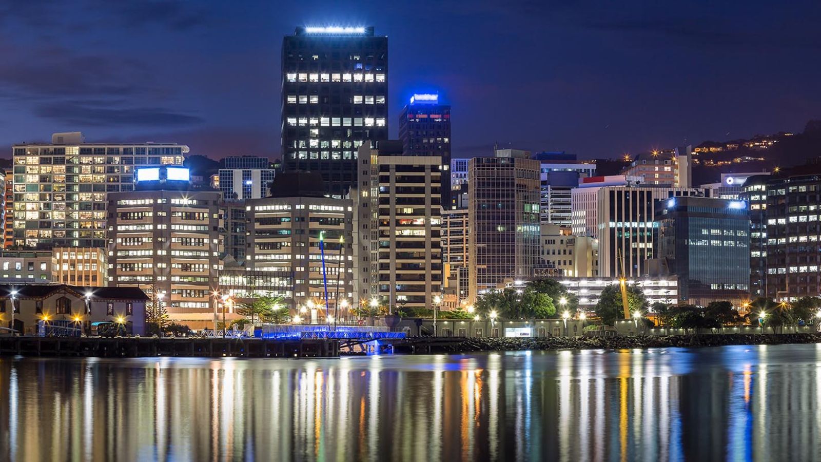 Shimmering lights on water with nighttime CBD in background