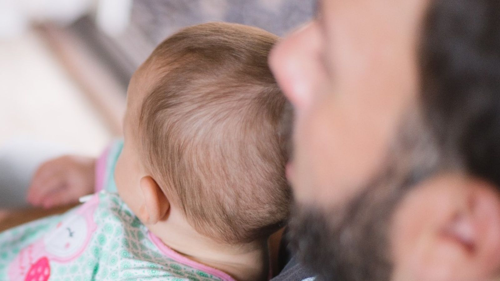 Shot from behind of man with baby in his lap