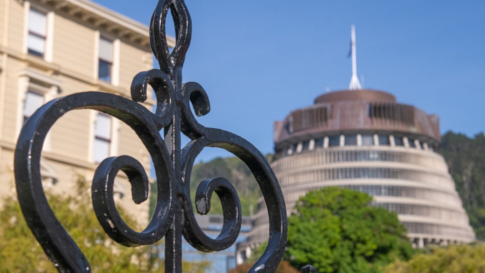 A photograph of buildings with an iron gate in the foreground