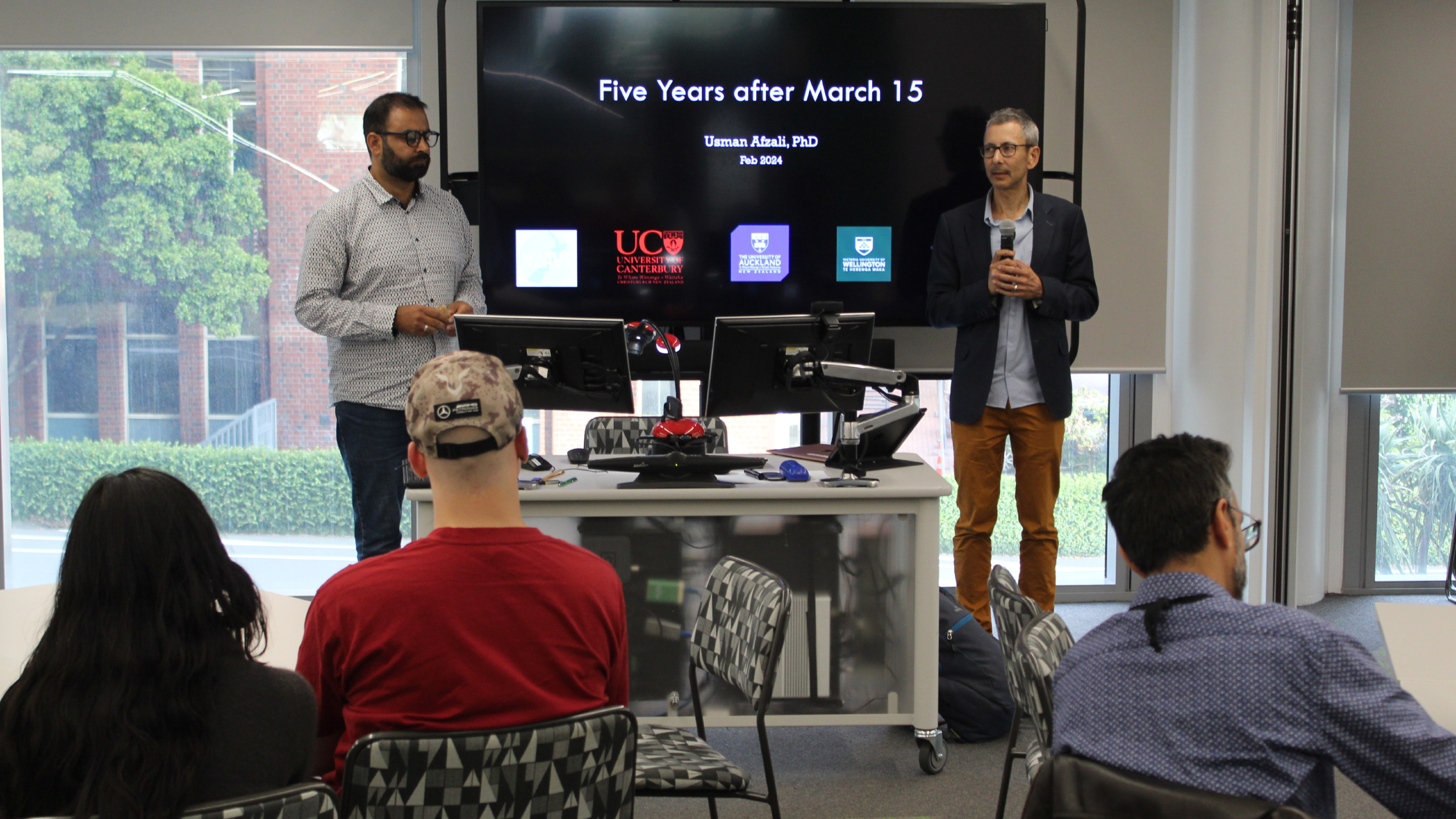 Joseph Bulbulia introducing Dr Usman Afzali in front of a screen that reads "Five years after 15 March".