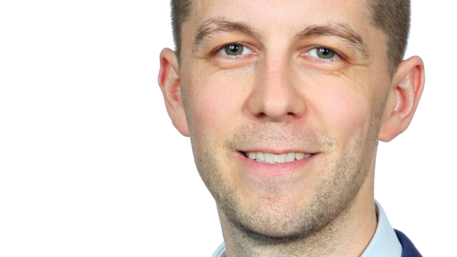 Close-up portrait of Daniel Carew smiling at the camera.