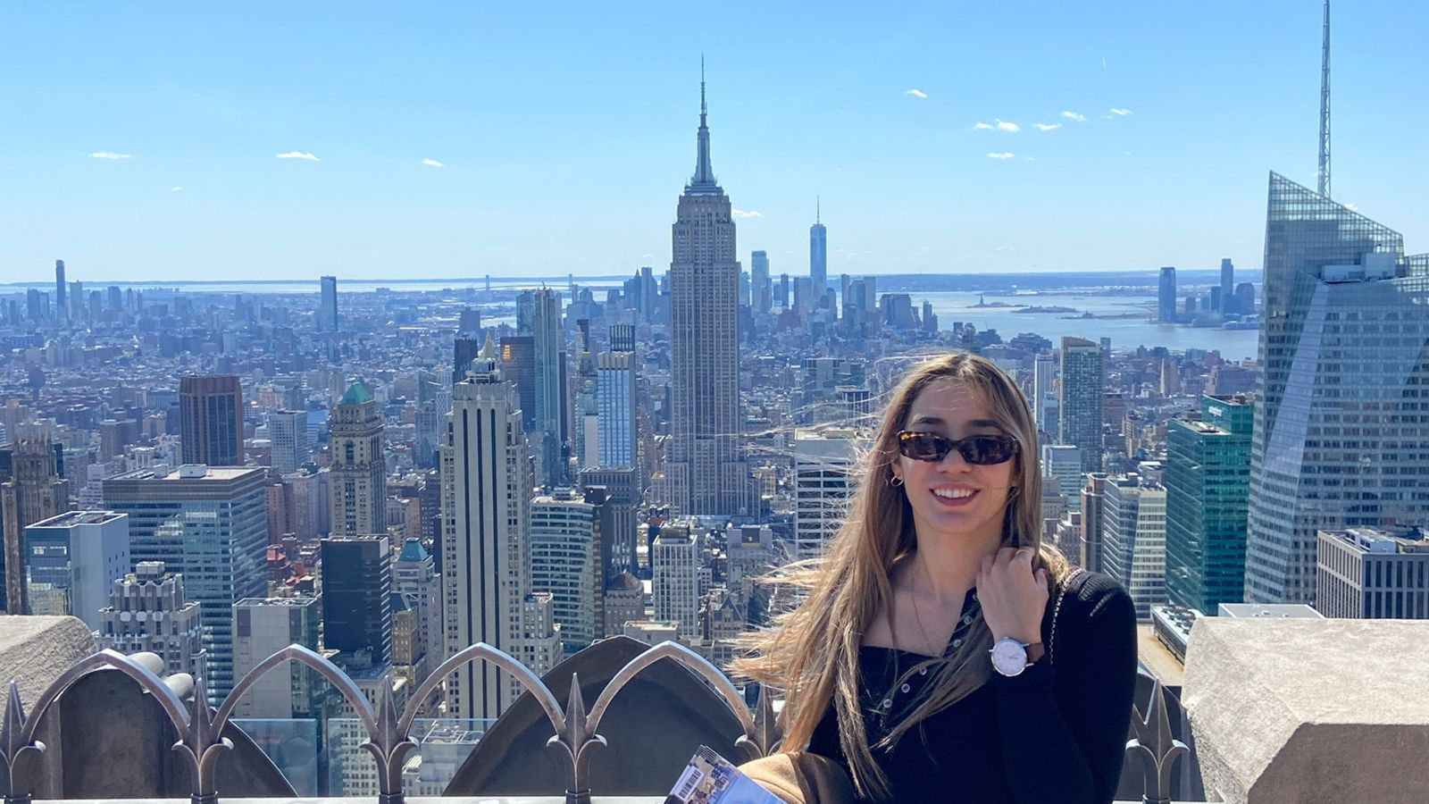 Zara Nathan smiles at the camera, the skyscrapers of Manhattan behind her.