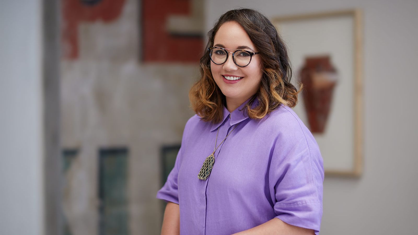 Portrait of Matariki Williams. Matariki has brown hair and wears glasses and a lilac-coloured collared shirt.