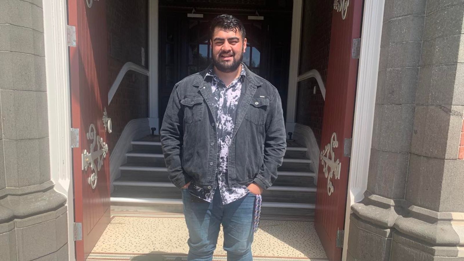 Photo of Fa’aaliga standing in front of the University's Hunter building