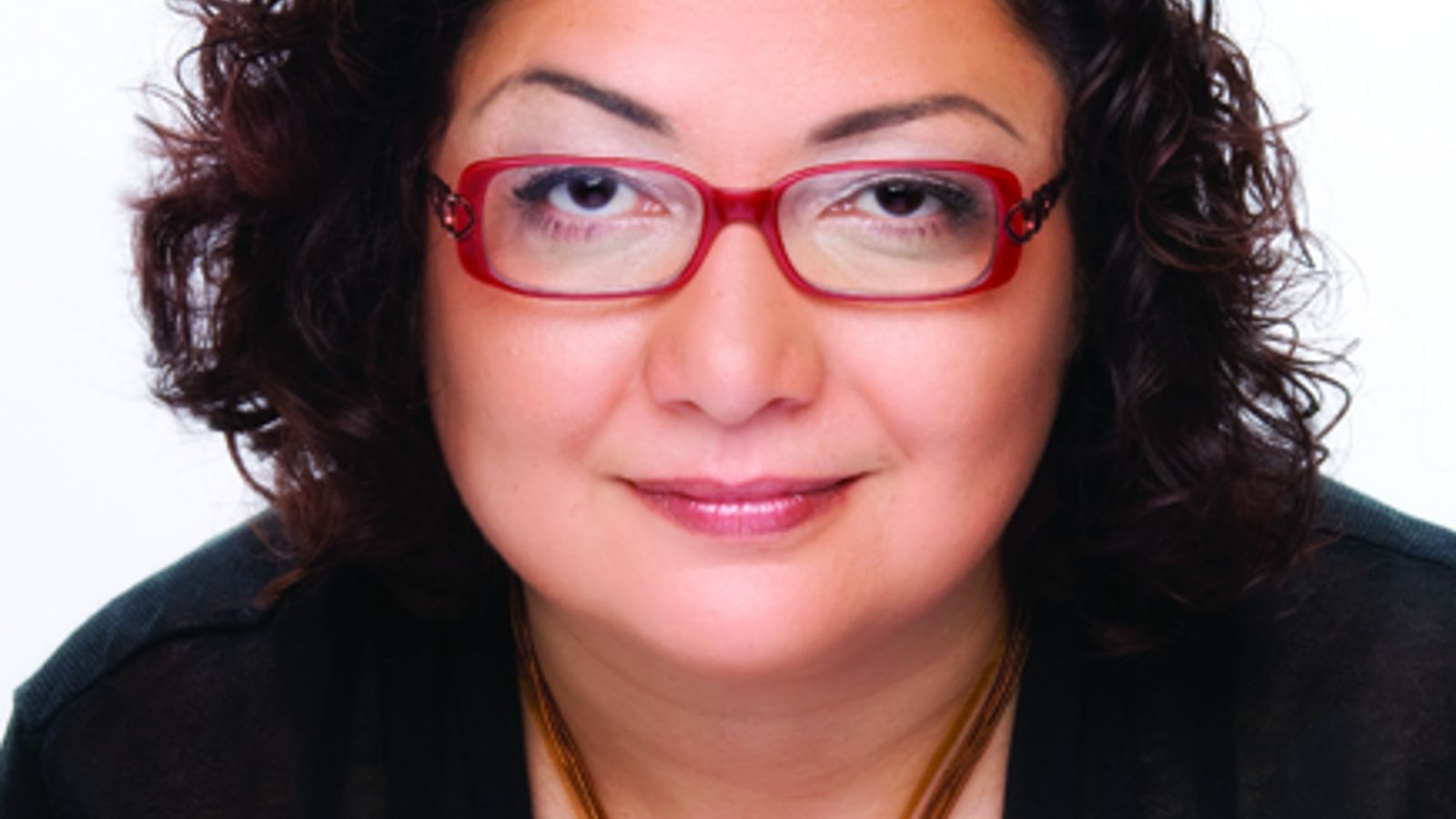 Portrait of Negar Partow. Negar has dark hair and wears red glasses.