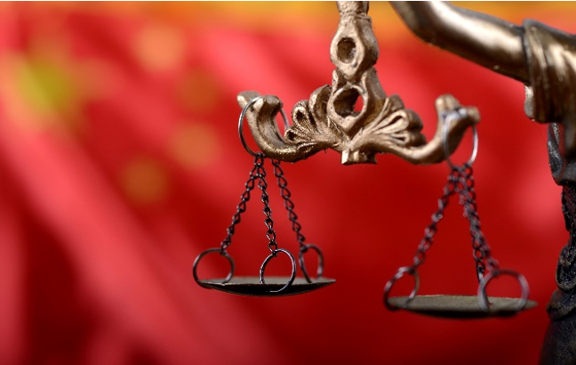 Depiction of the scales of justice in front of a Chinese flag