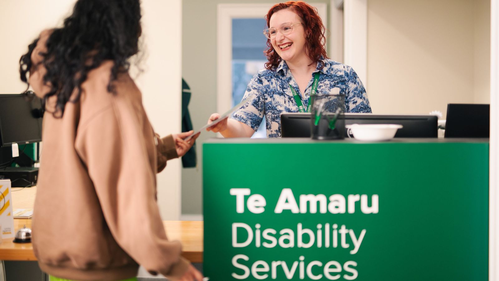 A student at the Disability Services reception desk being helped by a staff member