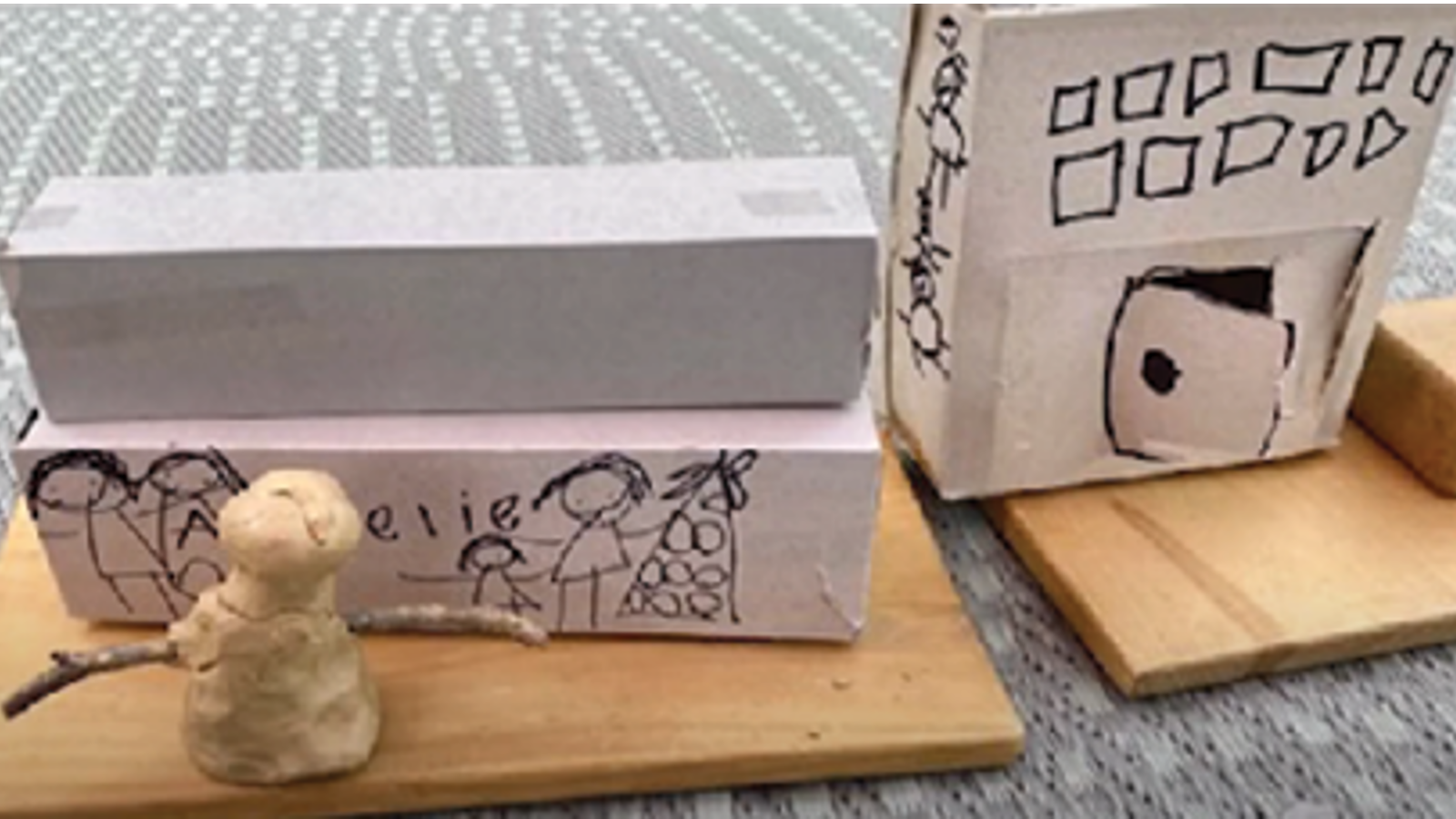 Child's artwork of cardboard boxes and clay figures.