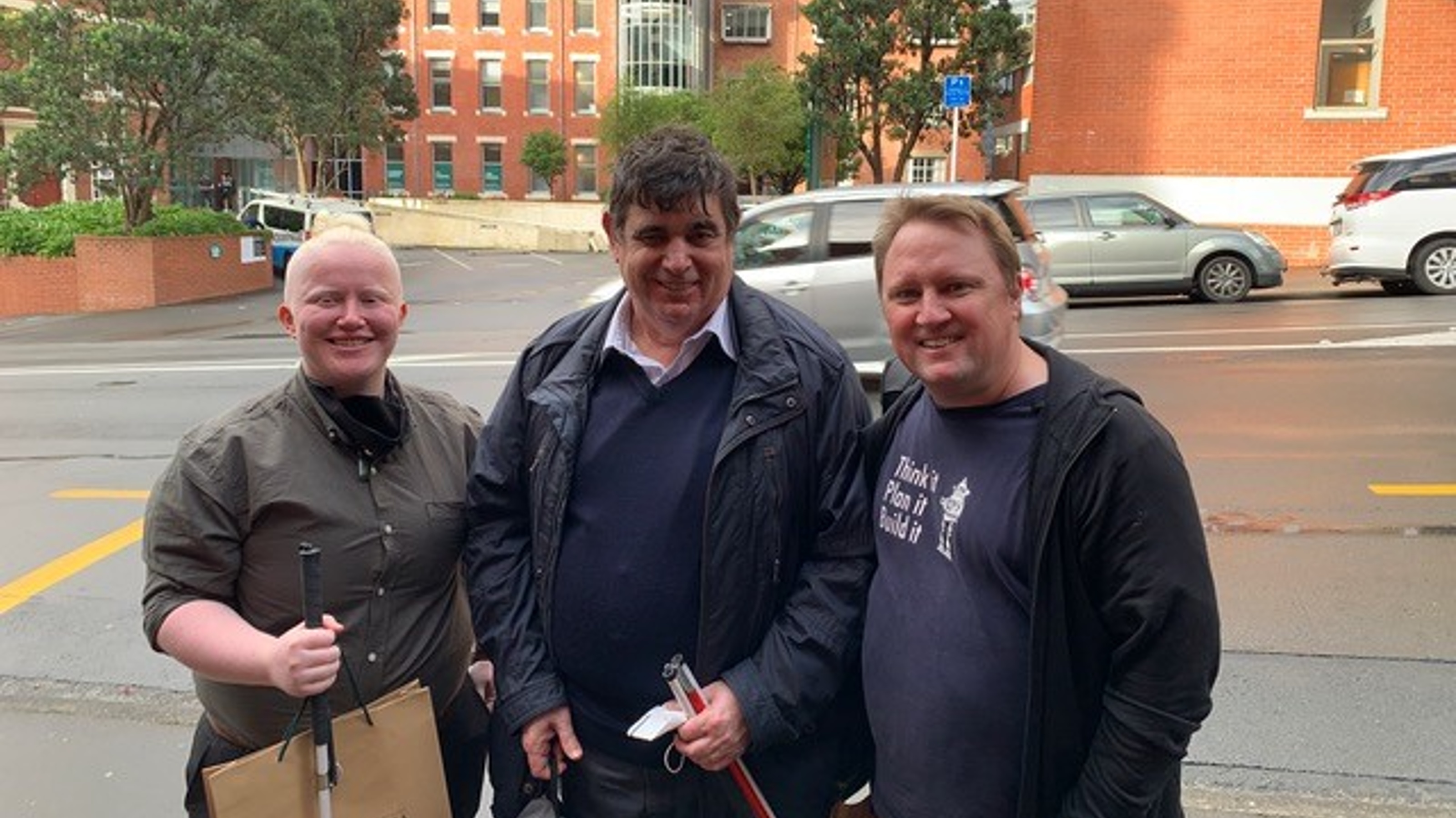 Bee Tapara, Thomas Bryan and Craig Anslow standing together on a footpath outside the University