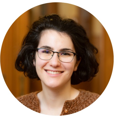 Woman with dark brown hair with glasses smiling