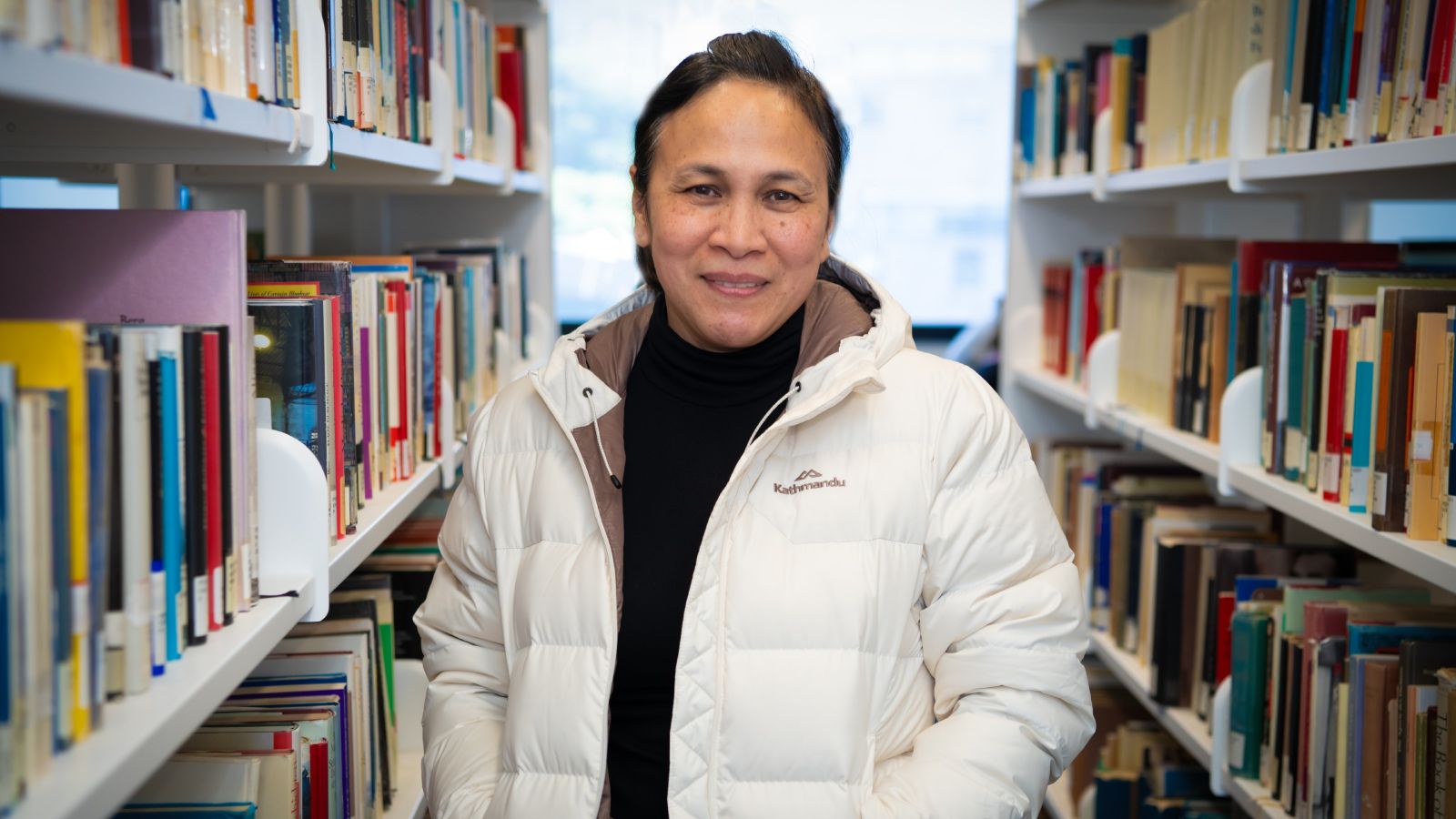 Ditas Yap in the library smiling at the camera.