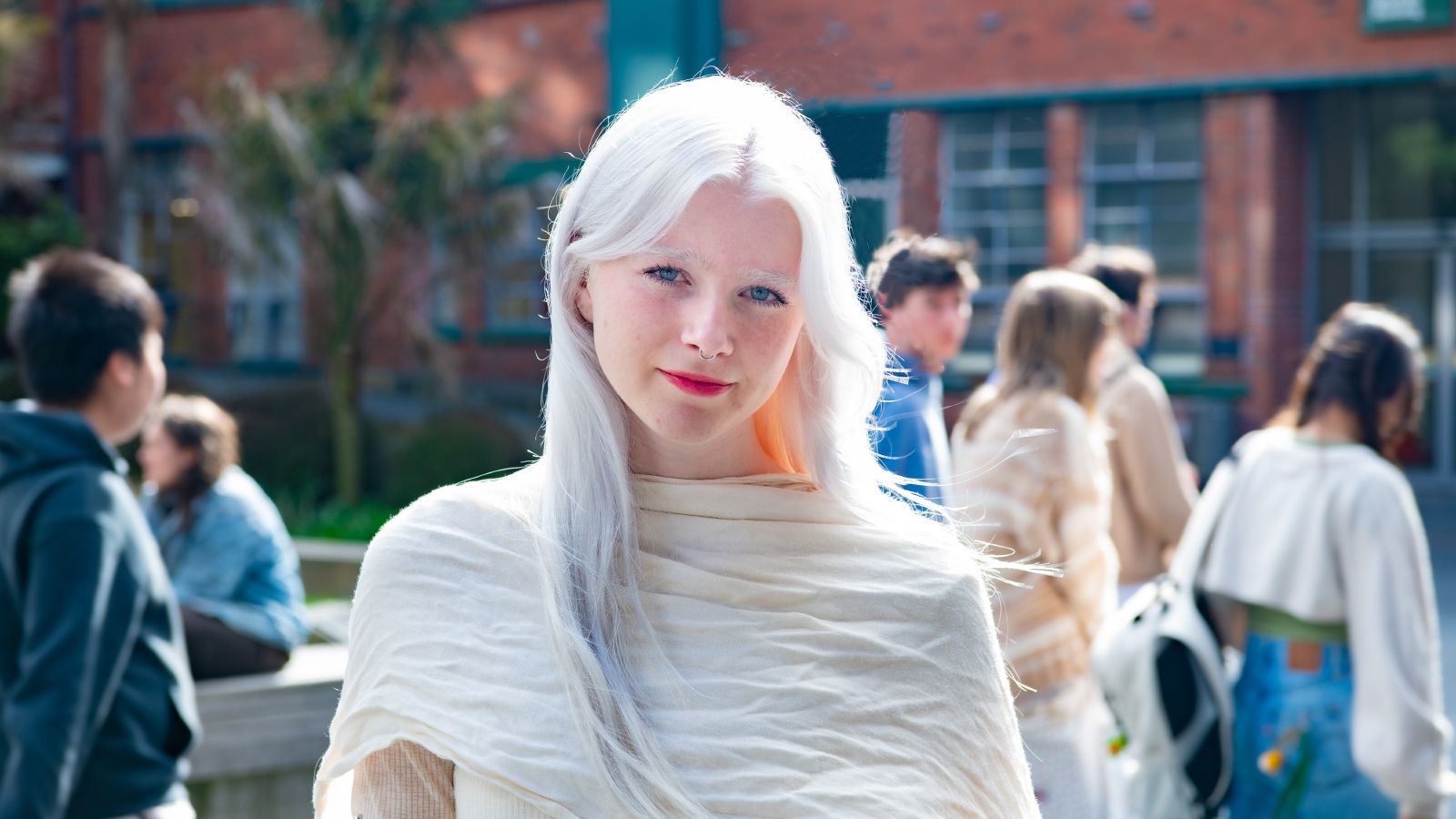 Student Aria Gardiner smiling at the camera. She is standing in the Tim Beaglehole courtyard.