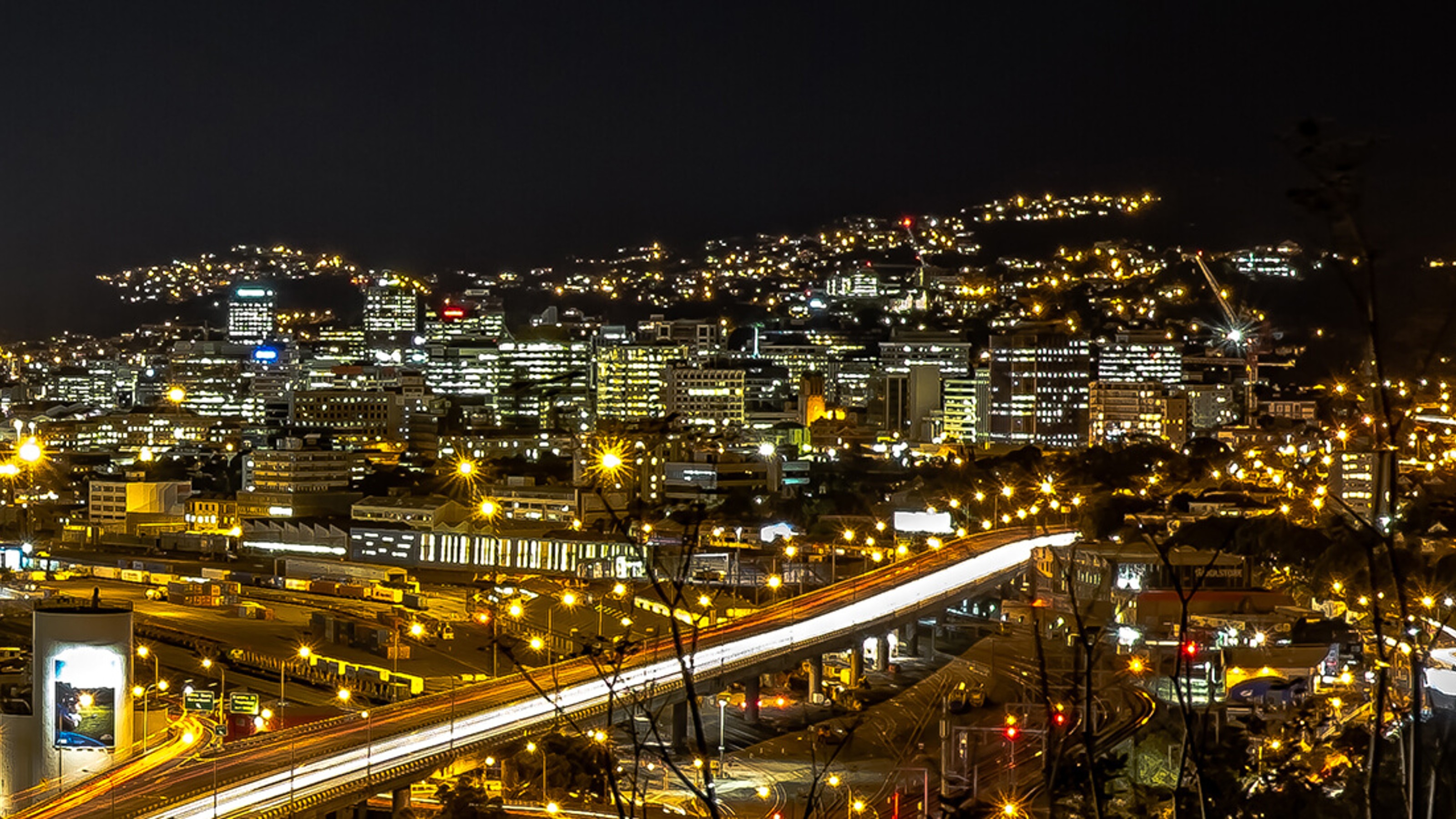 Aerial view of city, with street lights visible against a dark background