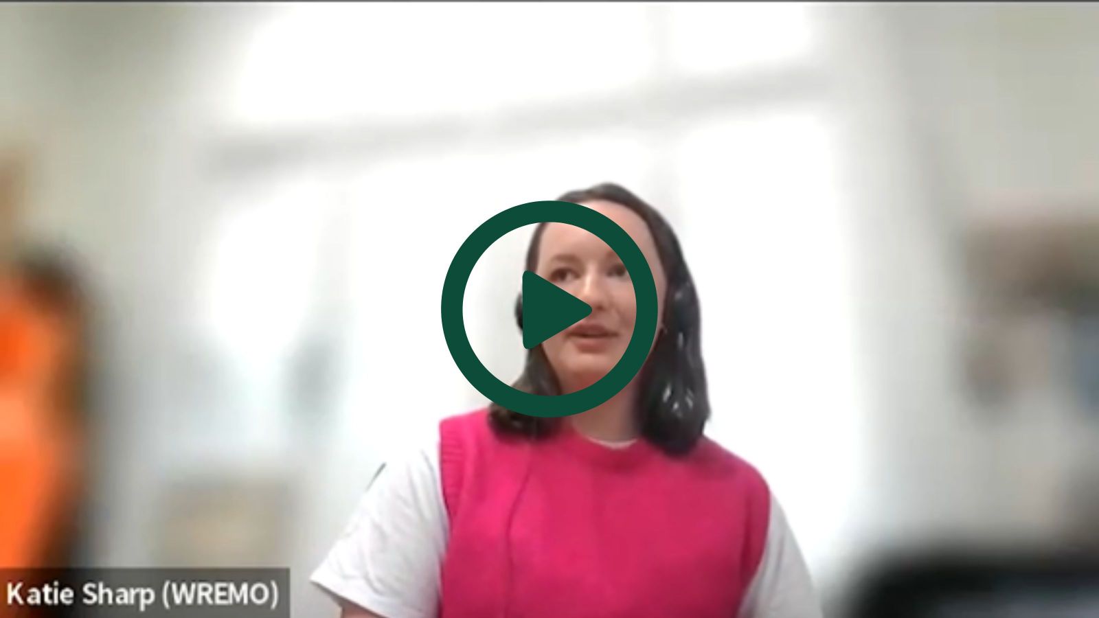 A screenshot of Katie on a Zoom interview with a play button overlaid