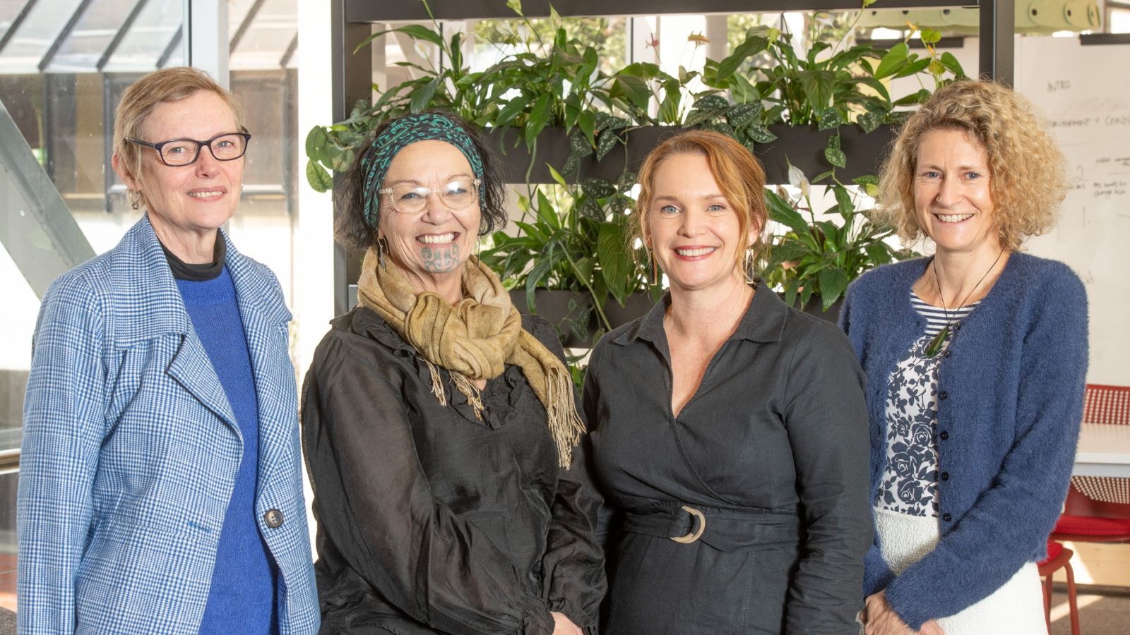 Four members of the centre research team pose for a photo with plants in the background