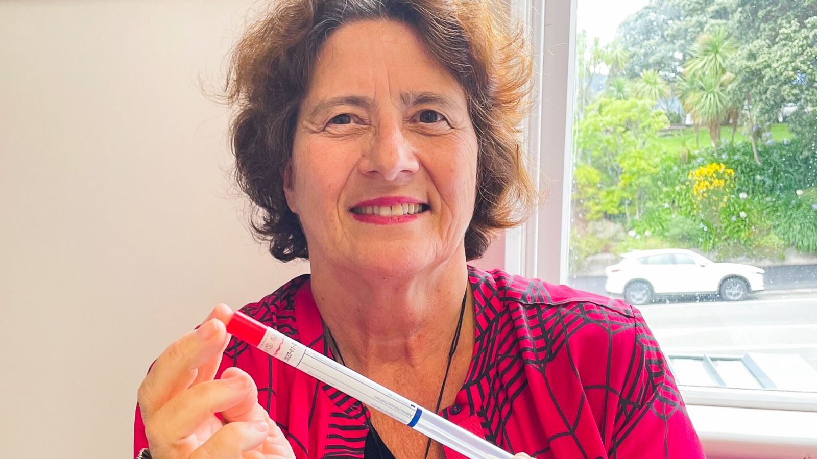 Professor Bev Lawton holds up the self-test swab