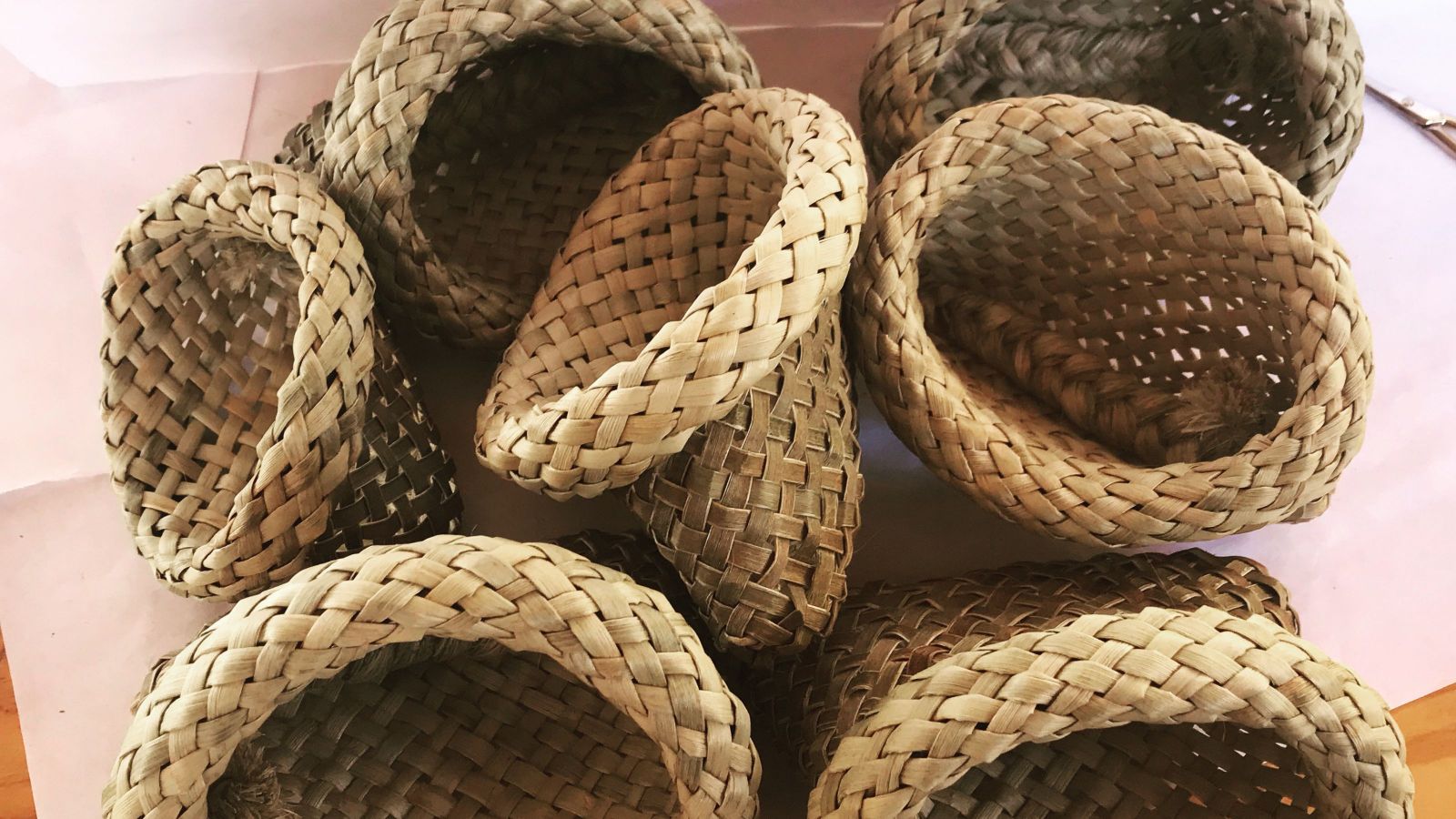 Several woven kete stacked on a table