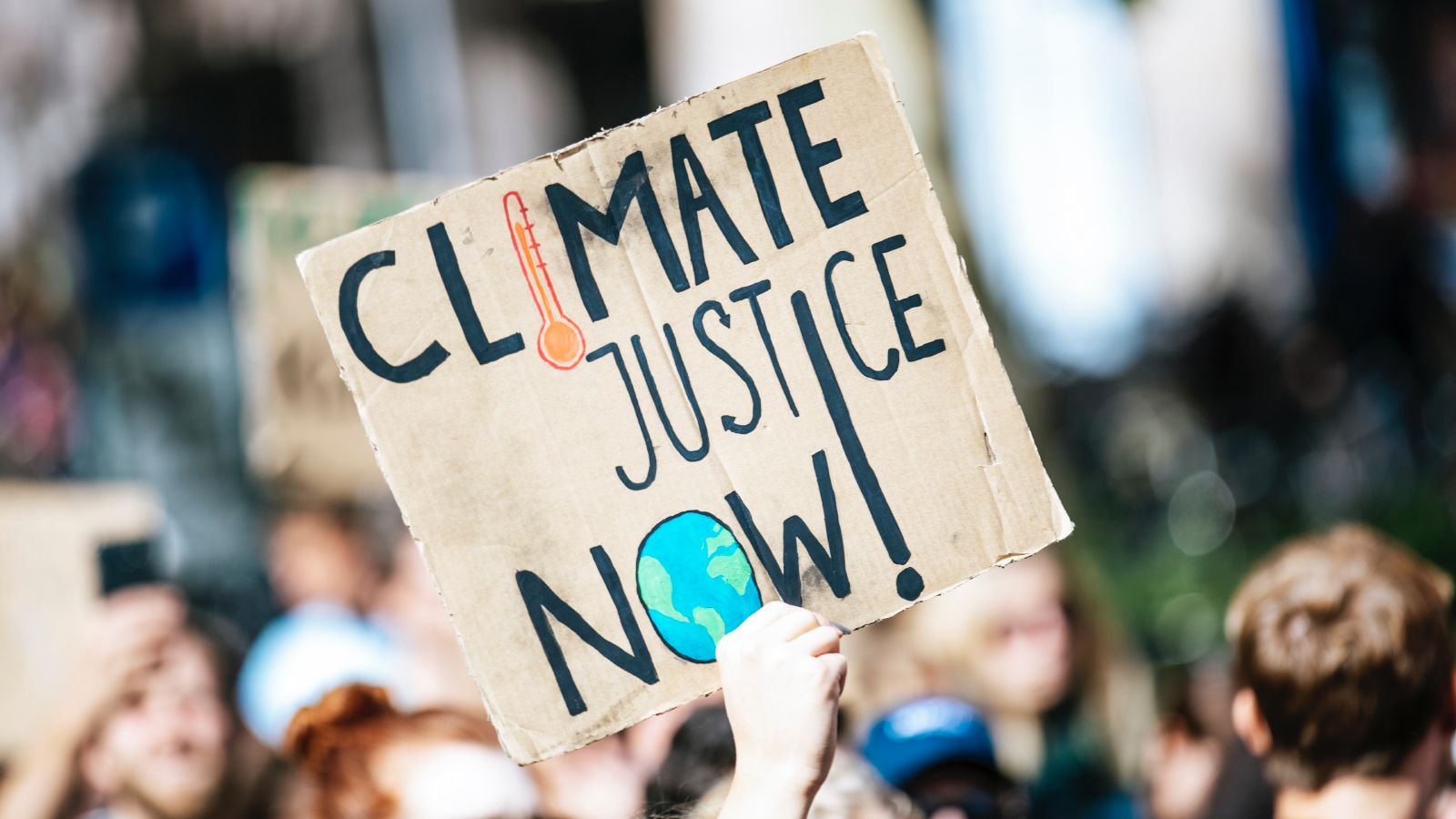 A sign at a climate change protest that says Climate Change Now!