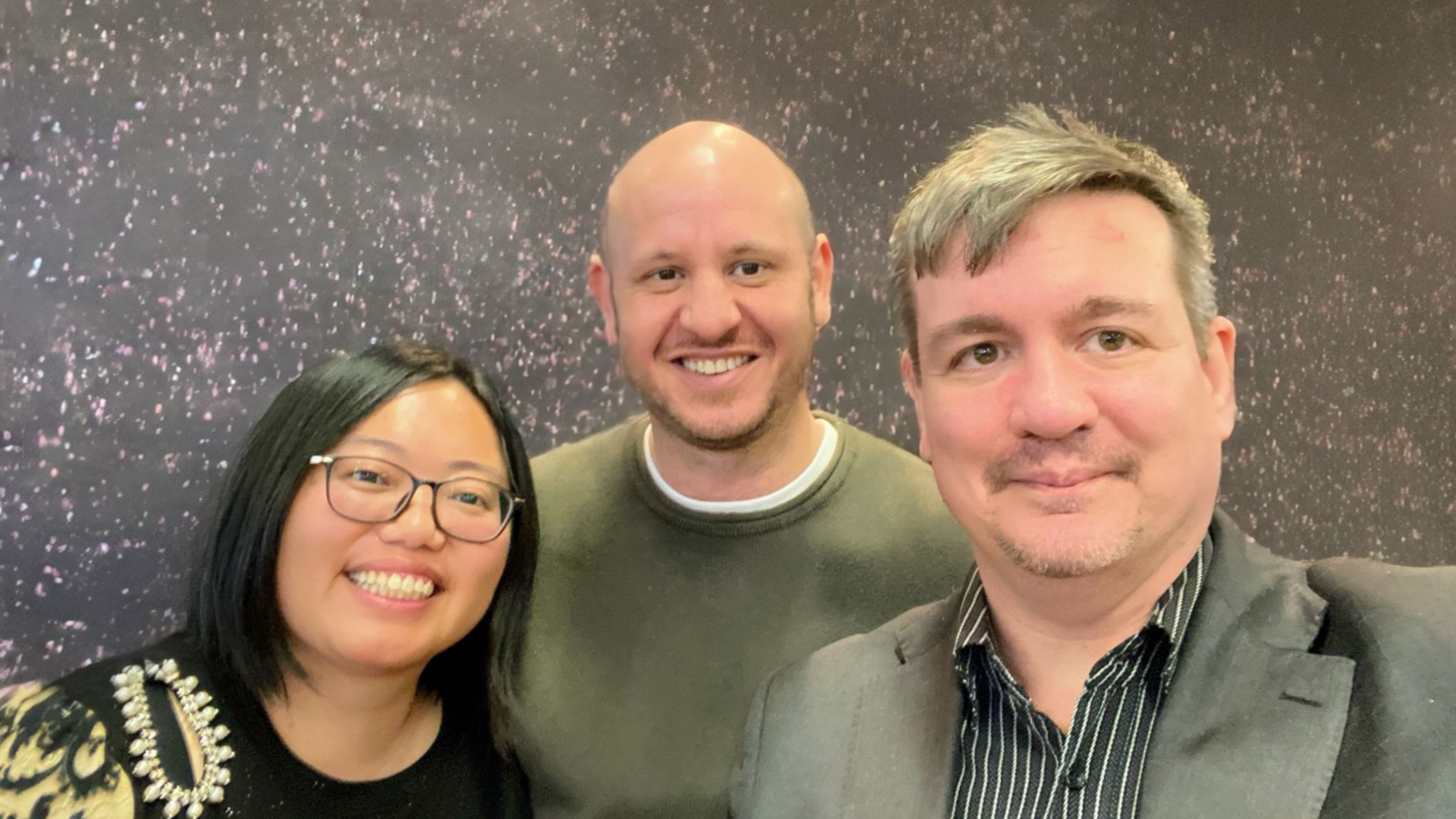 Three people smiling