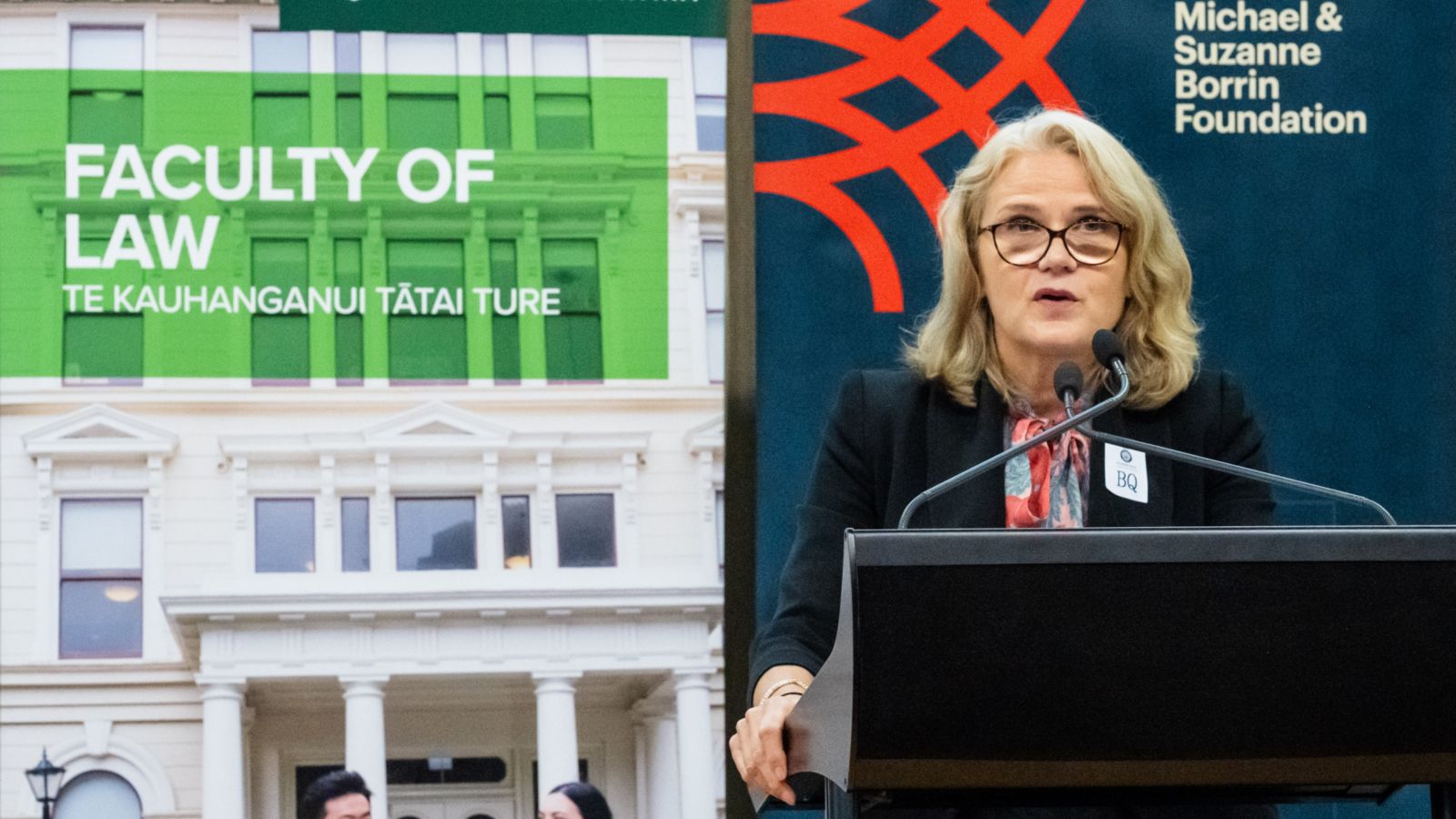 A woman standing at podium, delivering a speech.