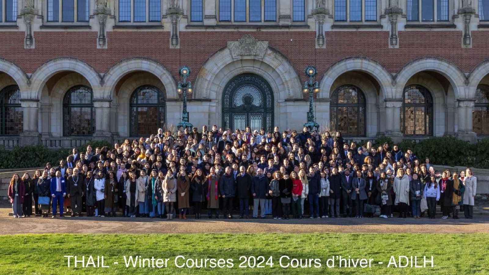 Professor Campbell McLachlan wears a scarf and stands in a group photo at the Hague 2024