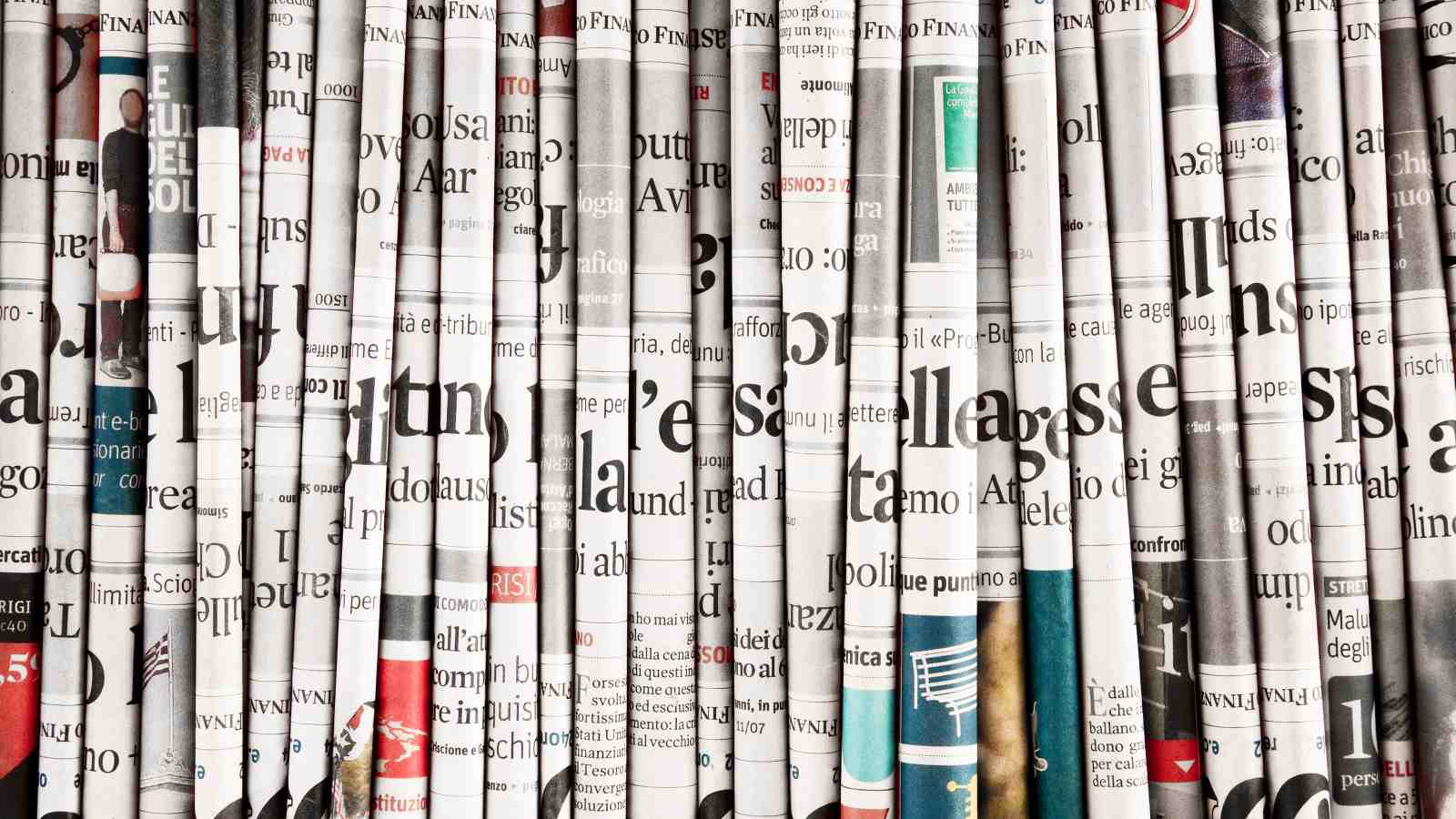 A stack of newspapers viewed horizontally from the side.