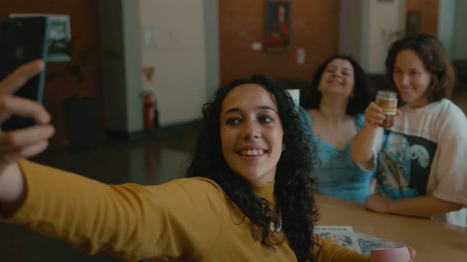 three girls taking selfie with reusable coffee cups