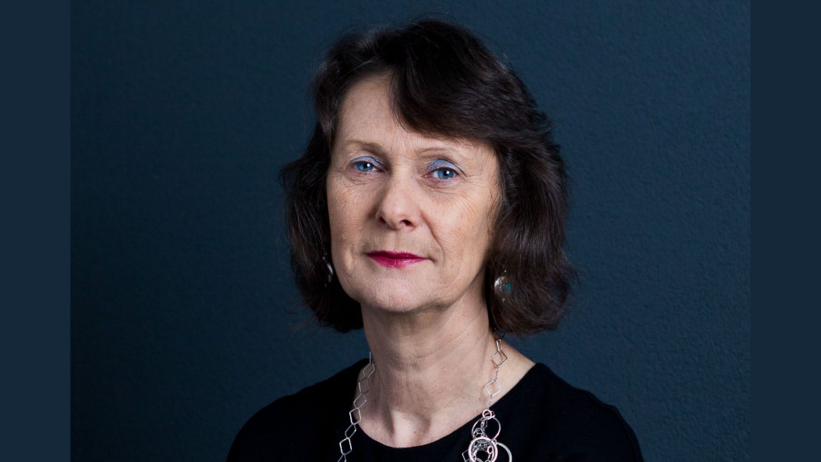 Woman wearing black clothes against dark blue background