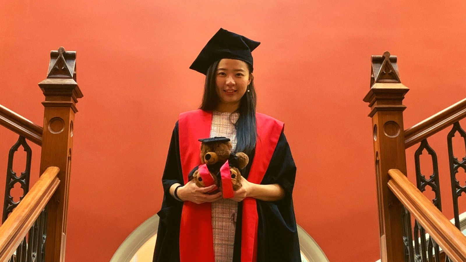 Doctoral graduate standing on stairs