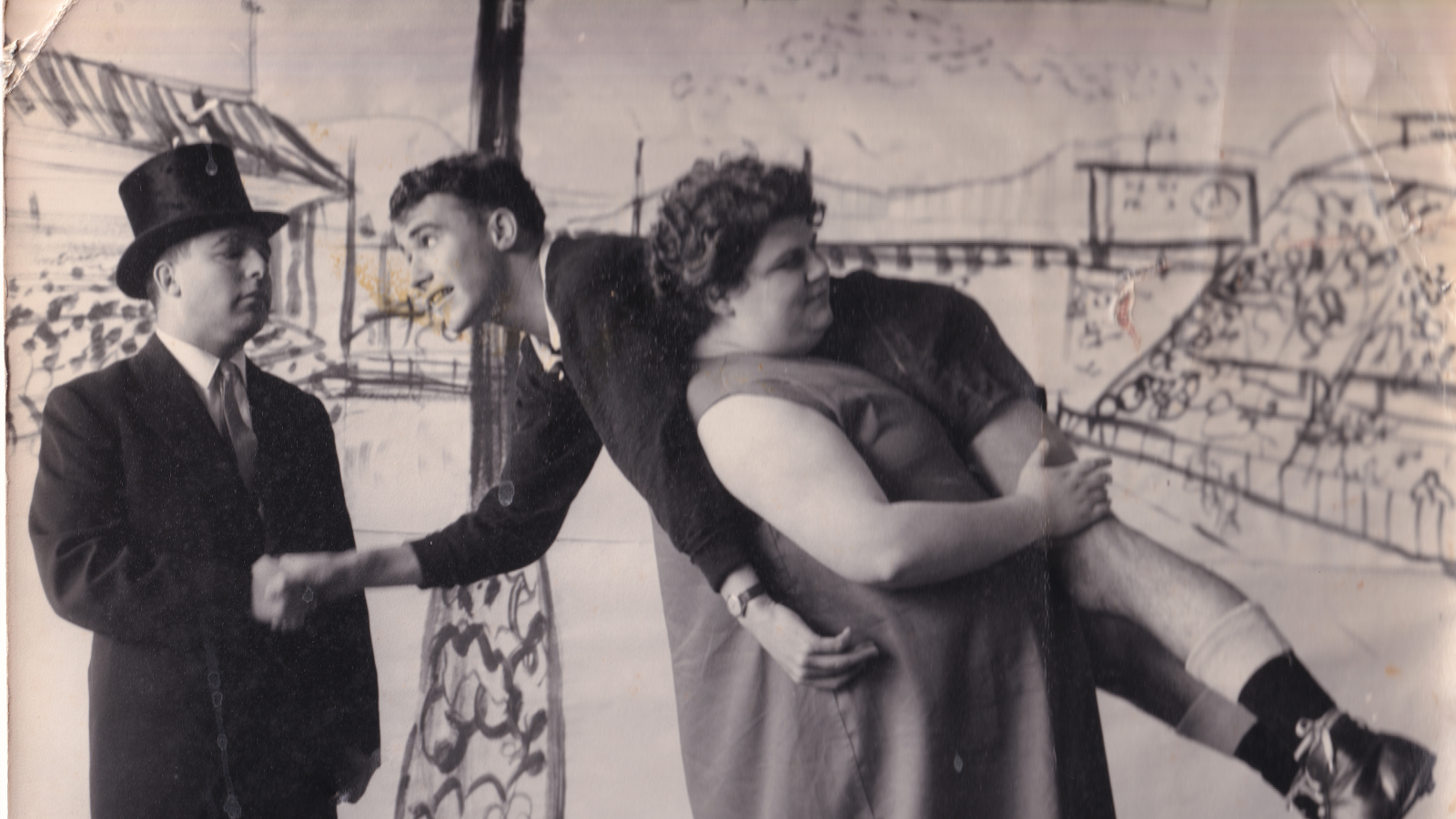 A restored photo from the 1960s of a woman carrying a man over her shoulder.