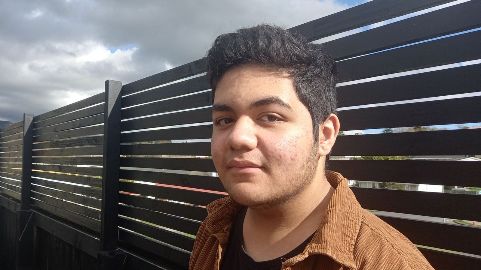 boy near fence smiling