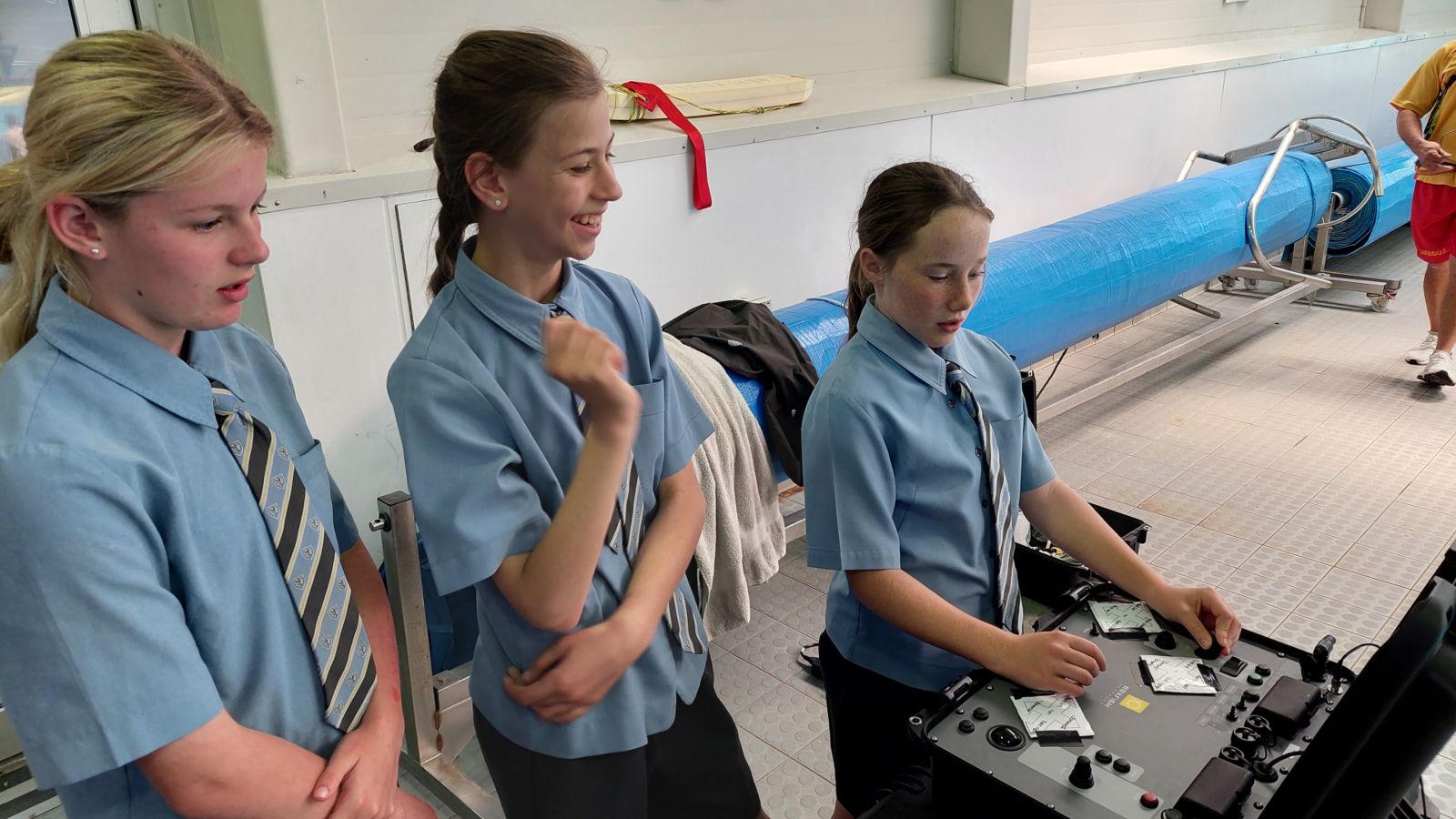 Students driving underwater drone in swimming pool