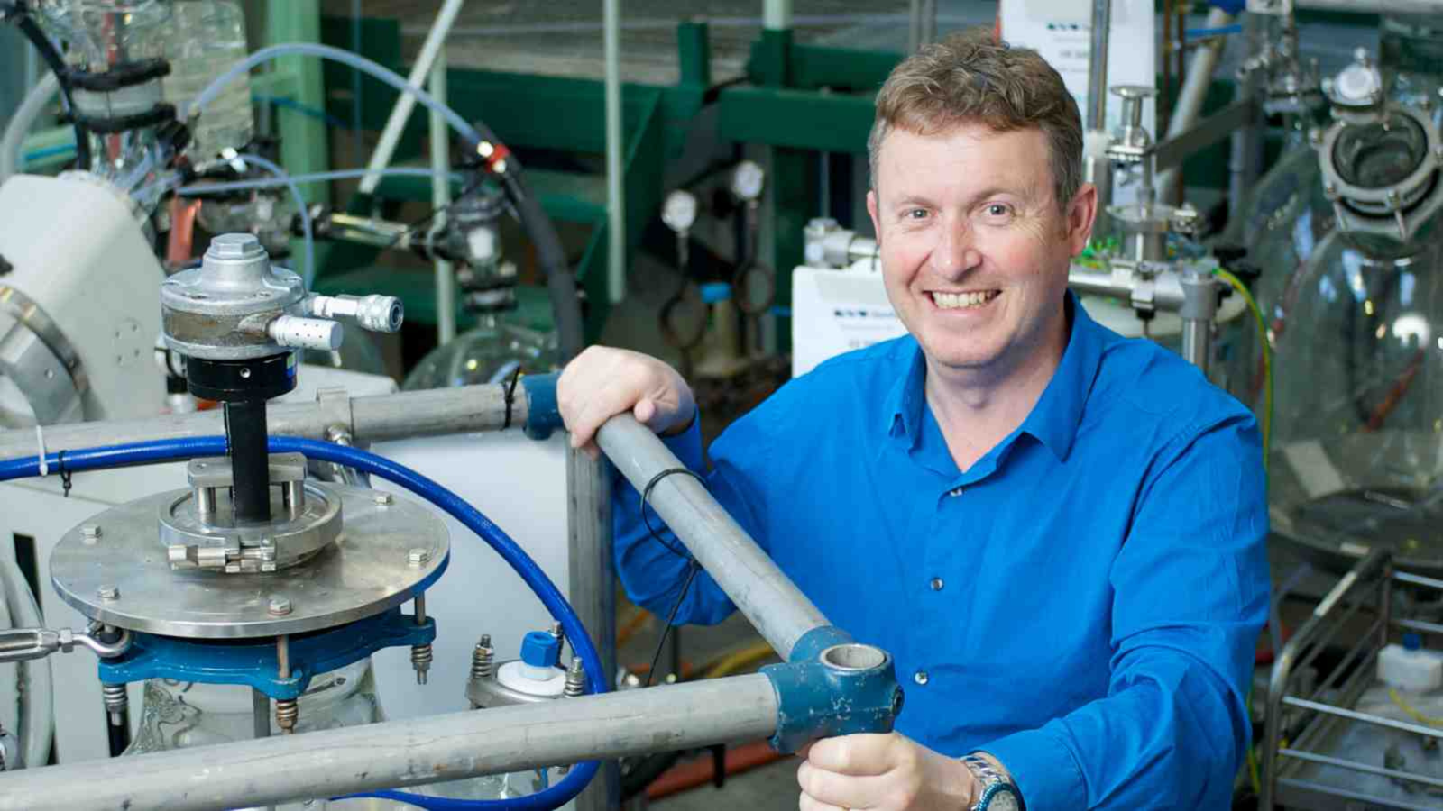 A man sits with a complex piece of machinery.