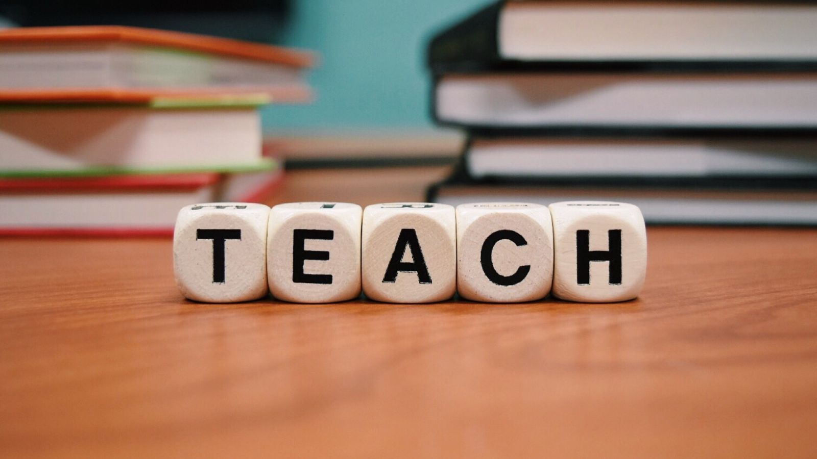 Dice spelling the word 'teach'