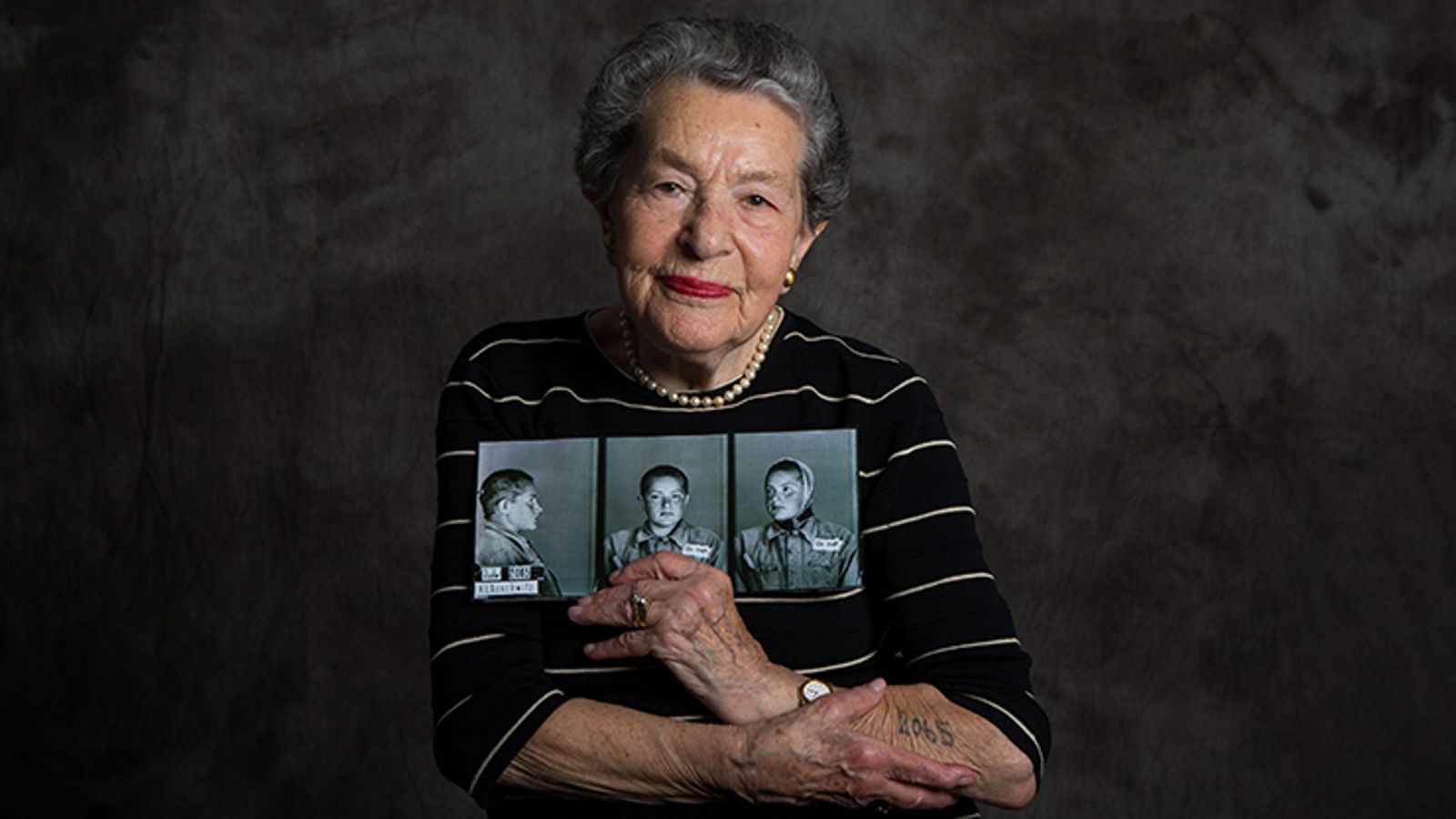 Woman holding up a series of photographs