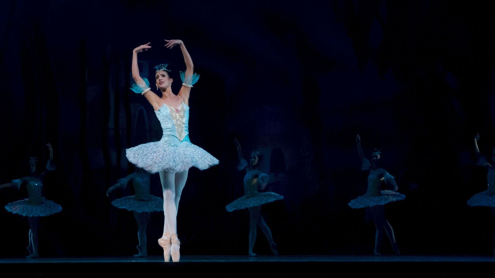 ballet dancer en pointe with a line of dancers behind her