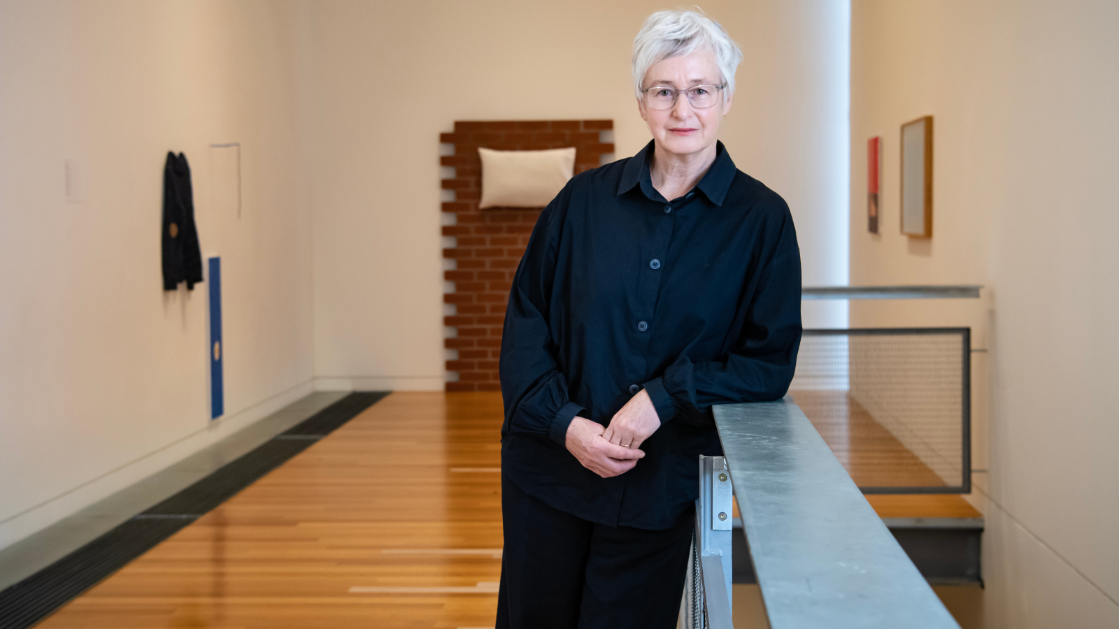 A woman stands in an art gallery.