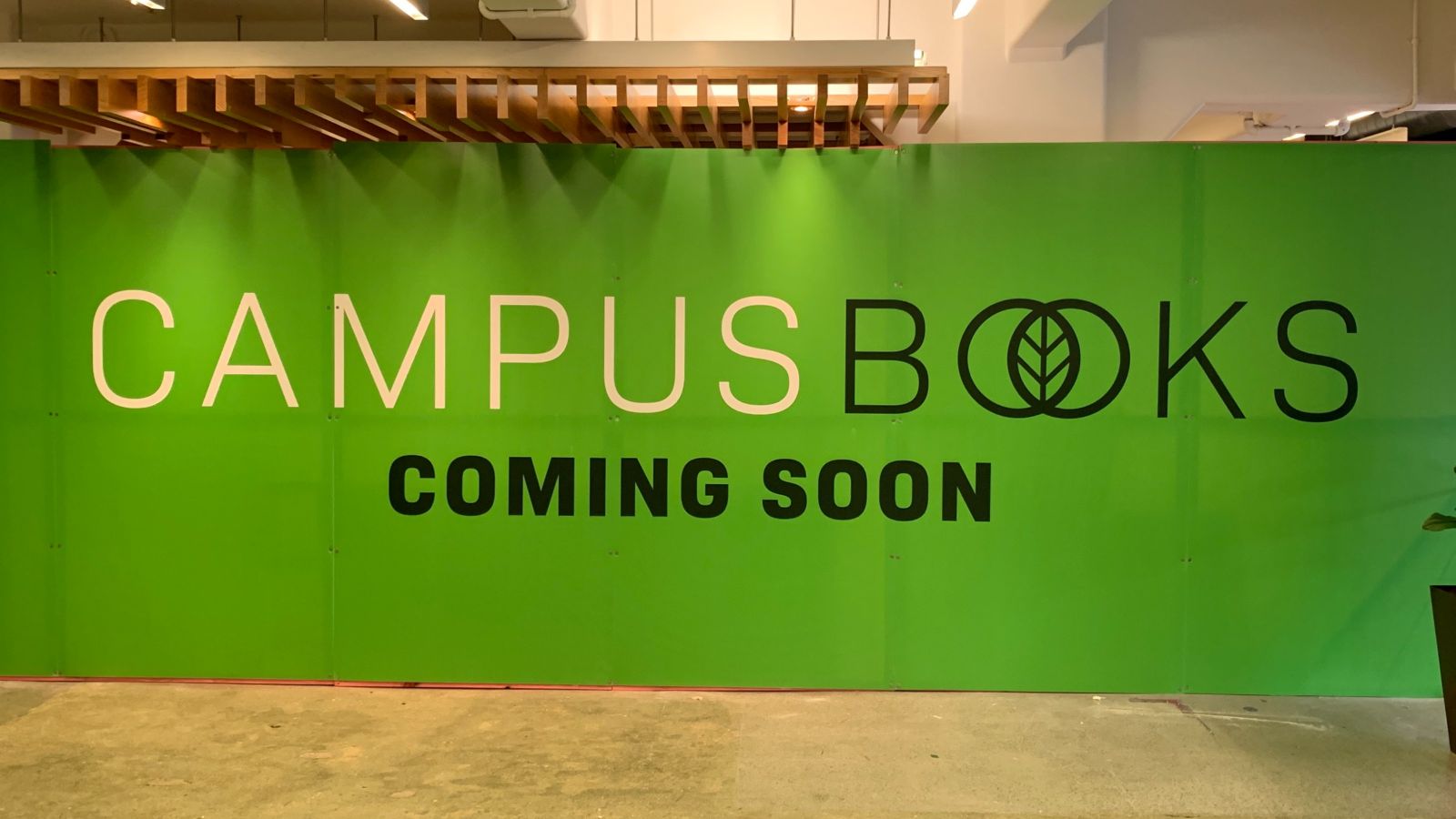 A green sign saying campus books coming soon.
