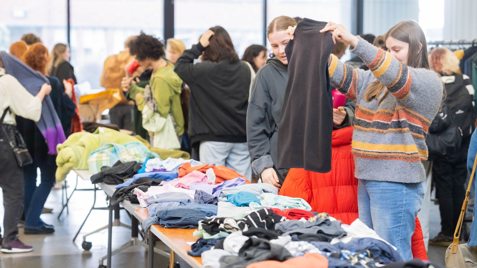 Two people select warm clothing at the clothing drive.